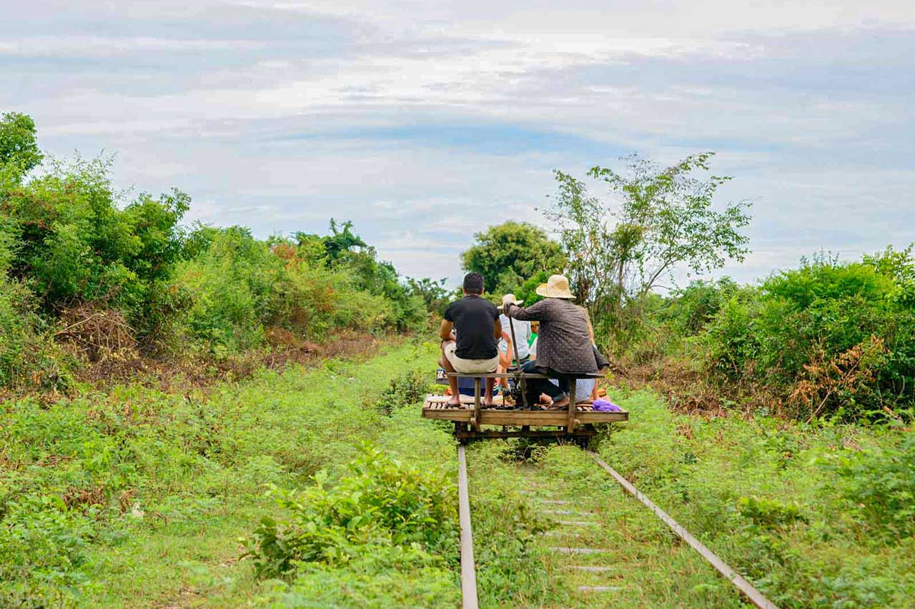 People-riding-a-bamboo-train-with-a-beautiful-nature-in-Battambang-Cambodia